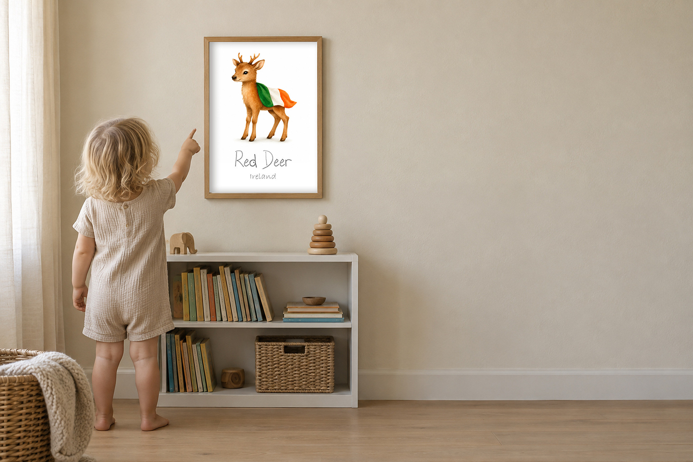 A toddler pointing at the flag on a framed print of the red deer of Ireland